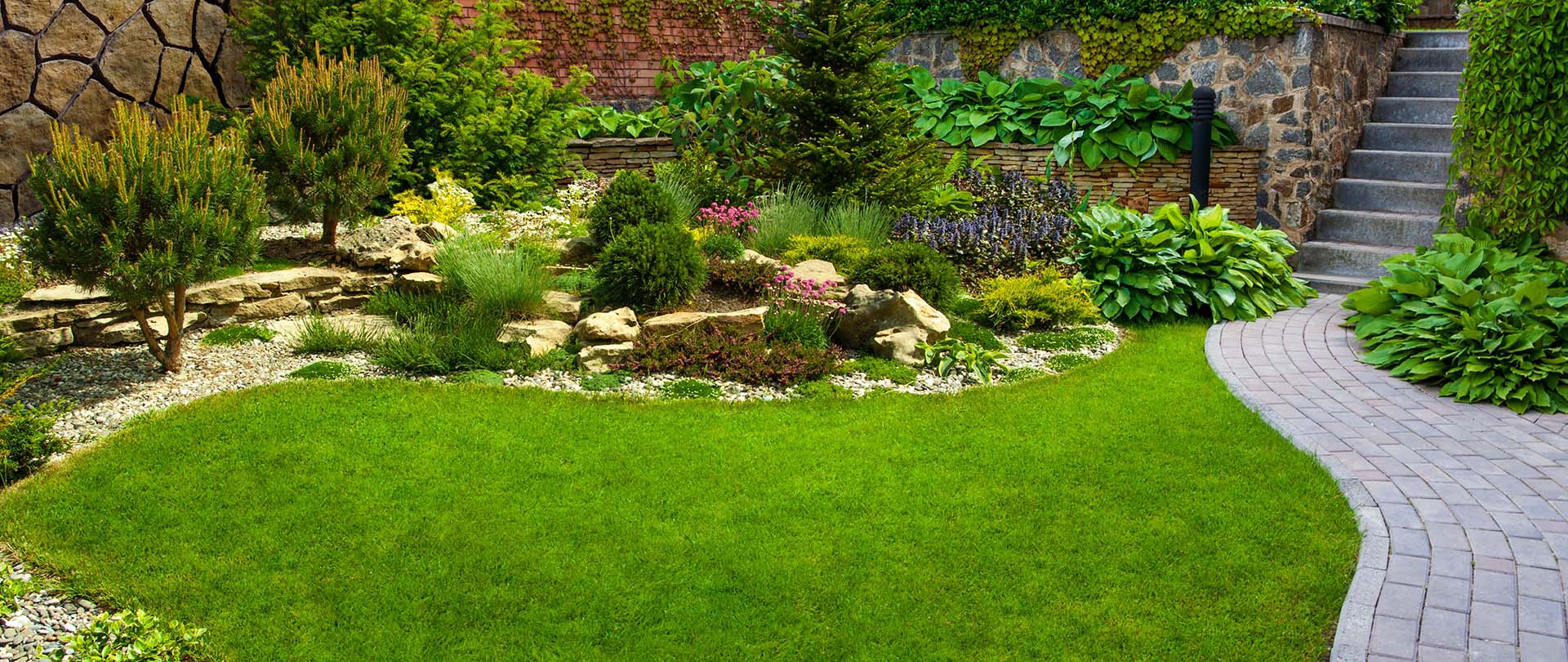 Ein grüner Garten mit Beeten und Steinen mittendrin | Heinrich Niestroj Haus- und Grundstücksservice
